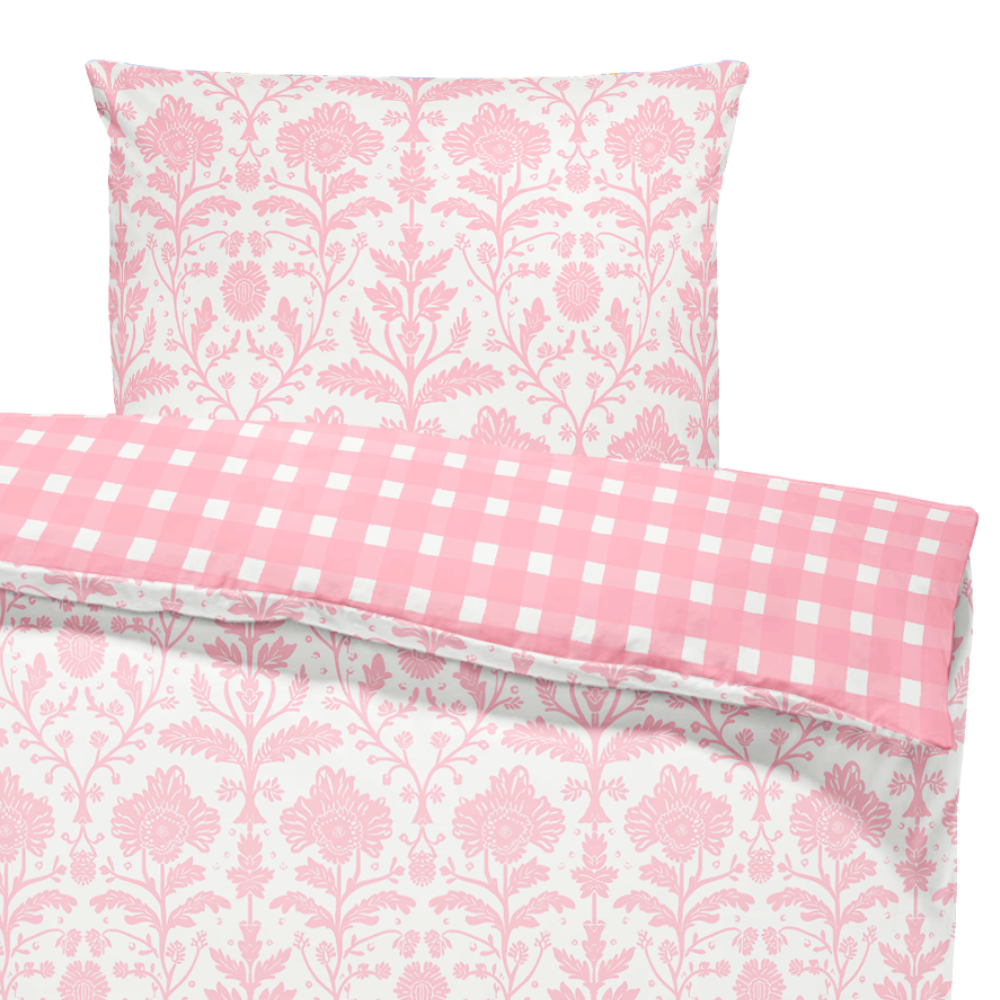 Pink floral and checkered patterned pillows on a white background