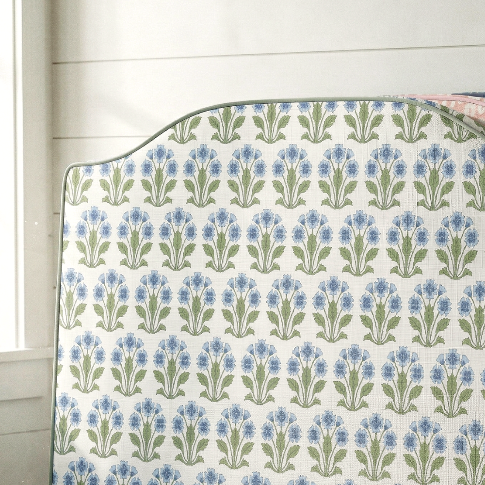 Floral patterned headboard against a white wall