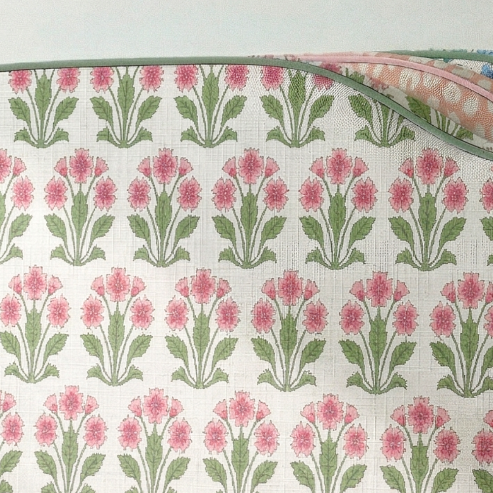 Floral patterned fabric with pink flowers and green leaves on a white background