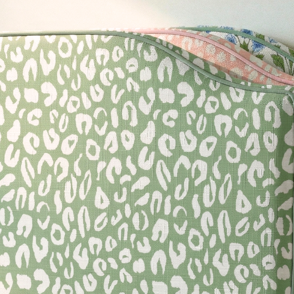 Green fabric with white leopard print pattern on a white background