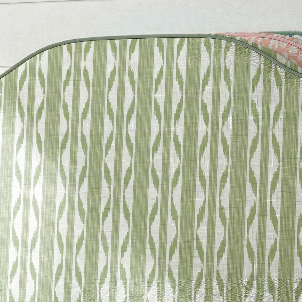 Close-up of green and white striped fabric with a subtle pattern.