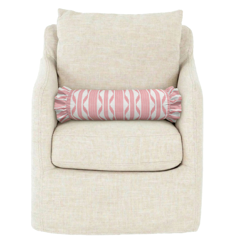 Beige armchair with a pink and white patterned cylindrical pillow on a white background
