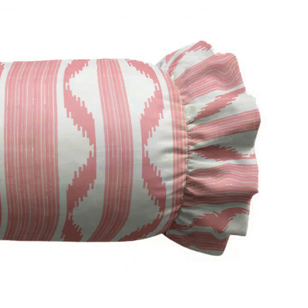 Zoom of decorative cylindrical pillow with a pink and white pattern on a white background
