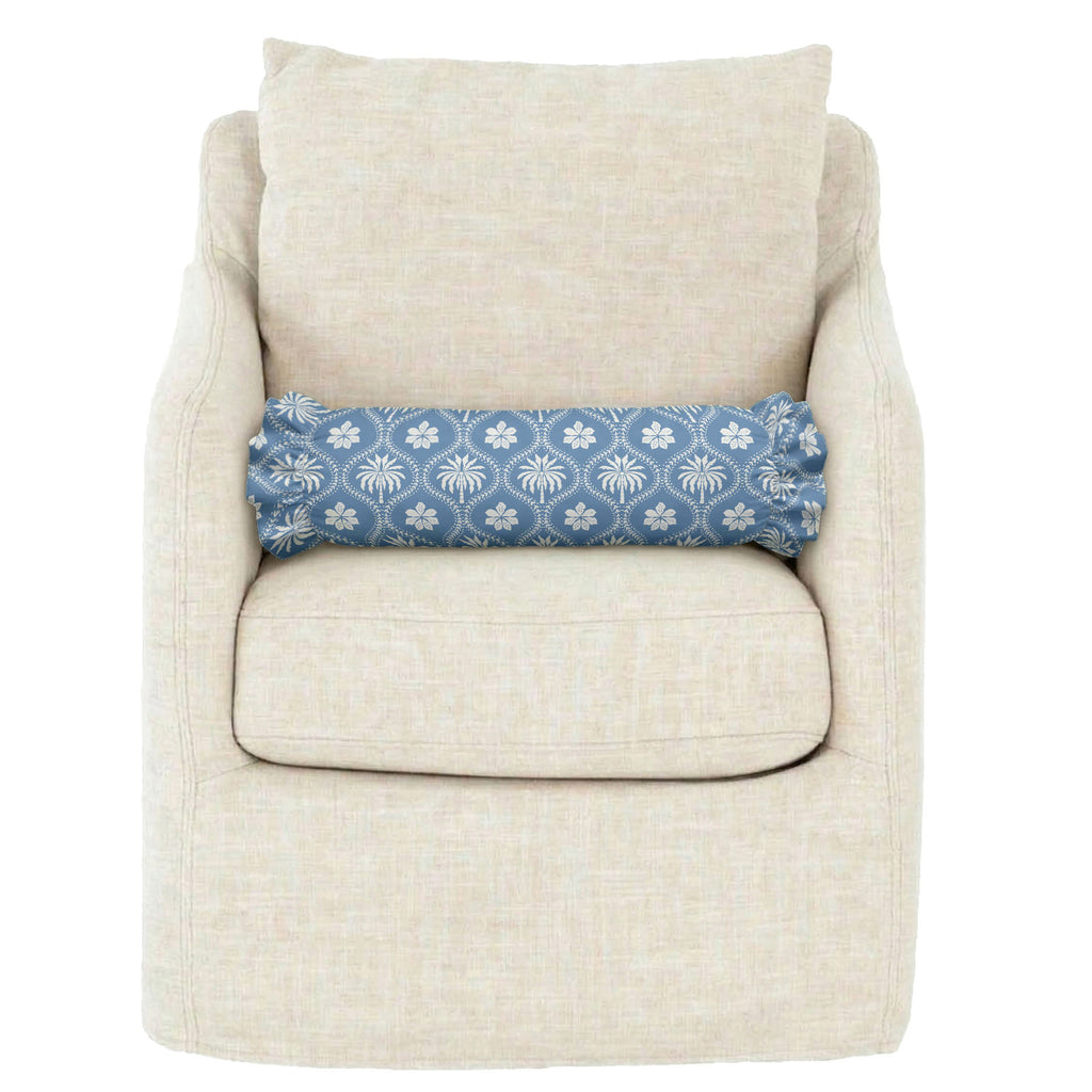 Beige armchair with a blue floral-patterned pillow on a white background