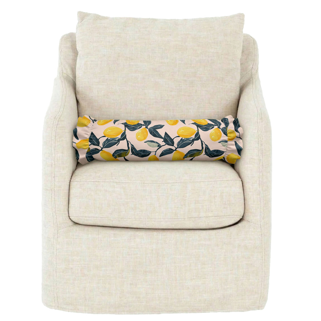 Beige armchair with a decorative pillow featuring lemon pattern on a white background
