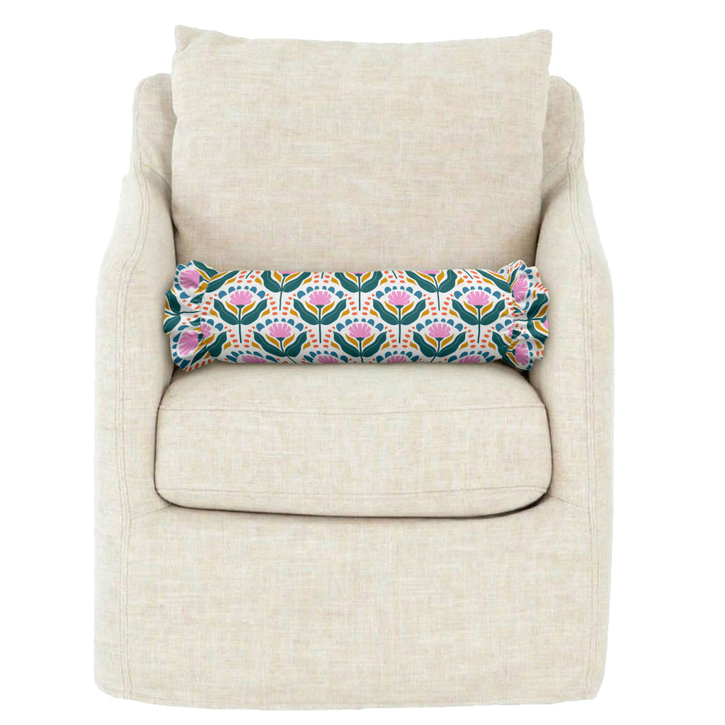 Decorative floral pillow on a beige armchair against a white background