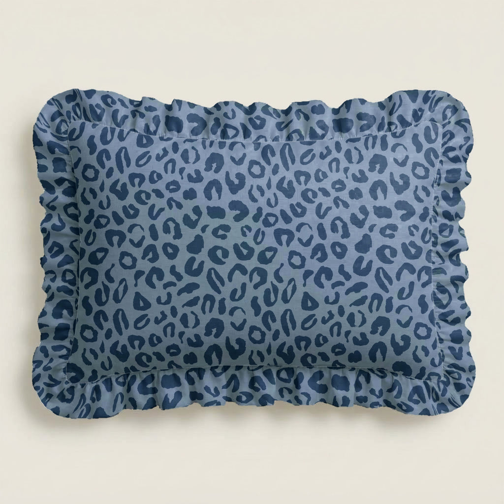 Blue leopard print pillow with ruffled edge on a beige background