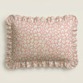 Pink pillow with white leopard print pattern on a beige background