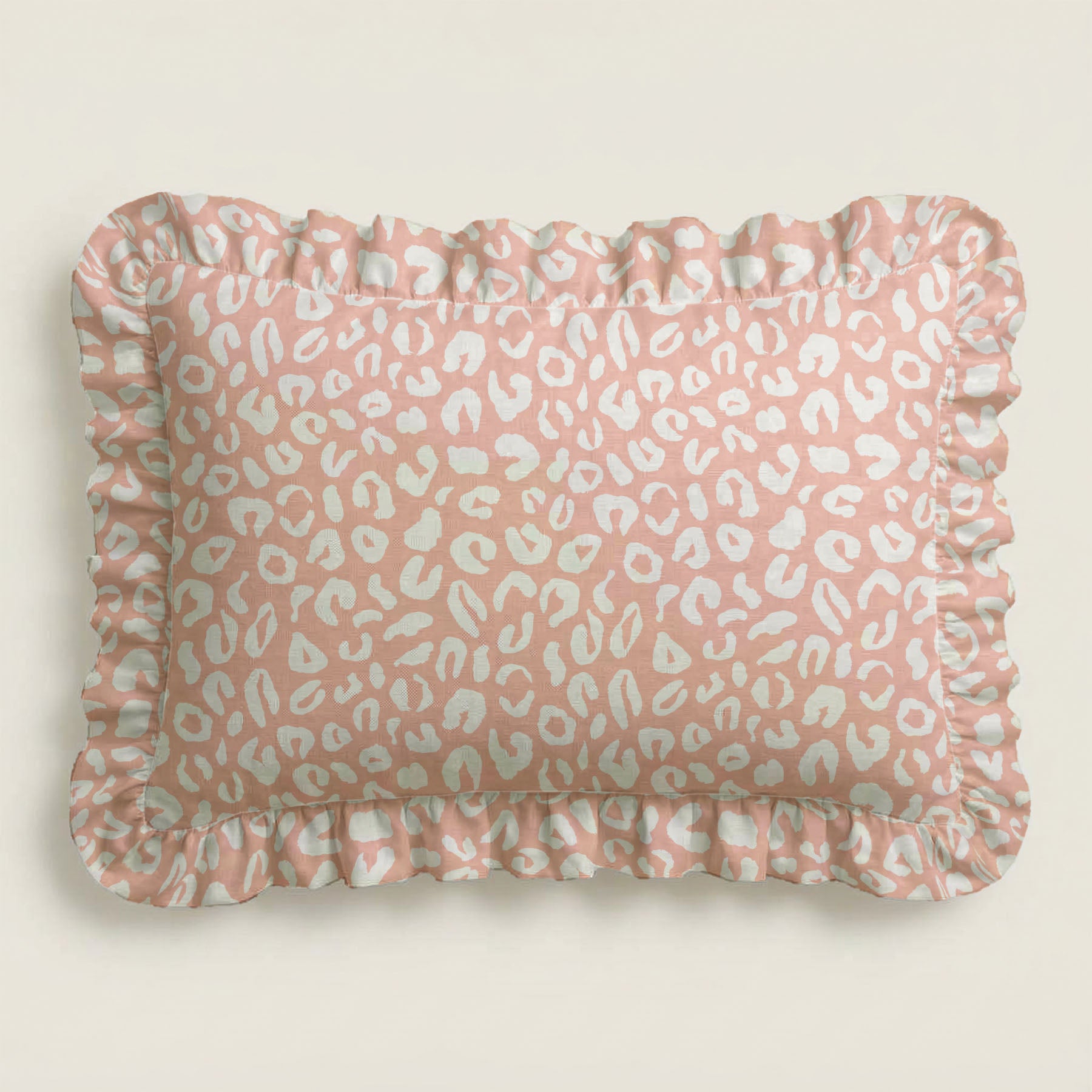 Pink pillow with white leopard print pattern on a beige background
