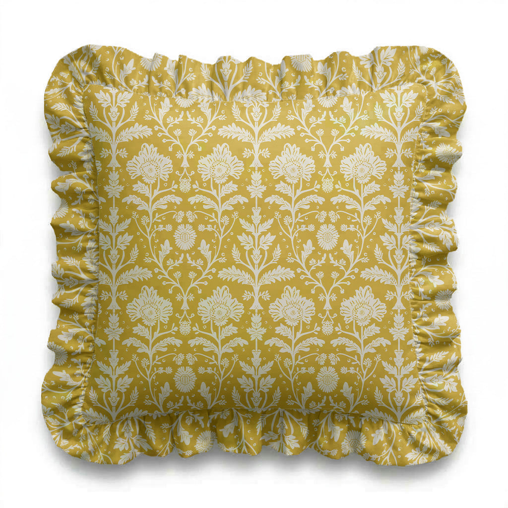 Yellow floral patterned pillow with ruffled edge on a white background