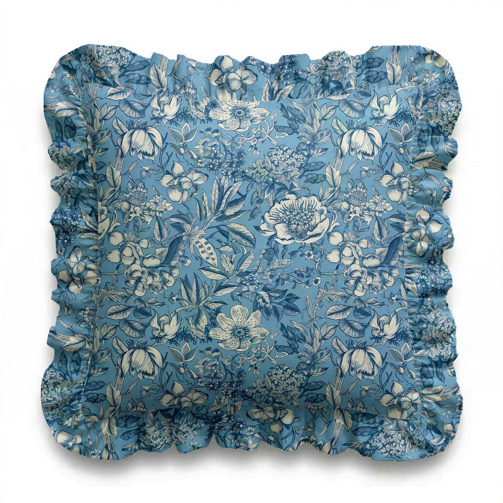 Blue floral cushion with ruffled edges on a white background