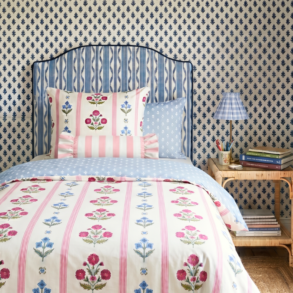Bedroom with floral bedding and patterned wallpaper