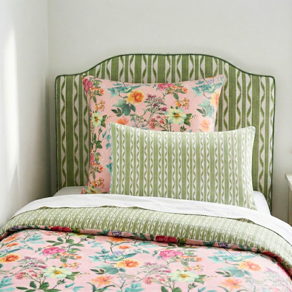 Bed with floral and green patterned bedding and headboard.