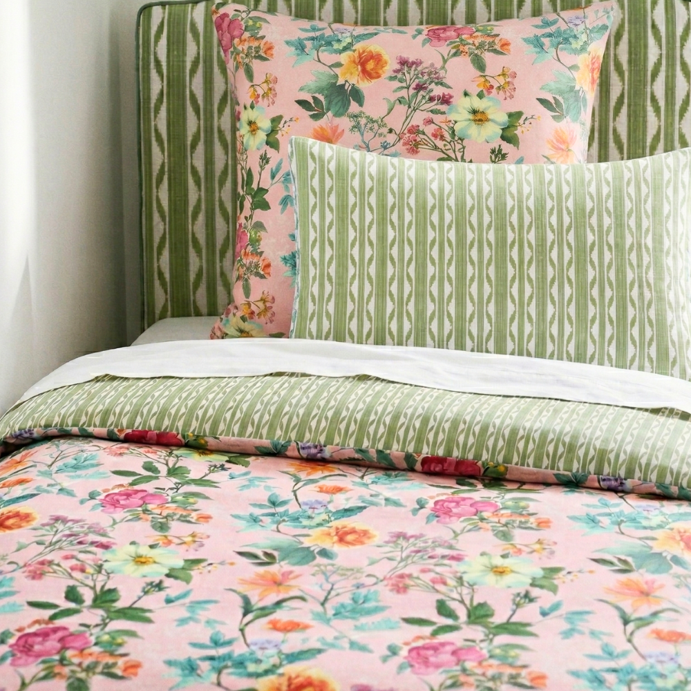 Floral and patterned bedding set on a bed with a floral pillow.