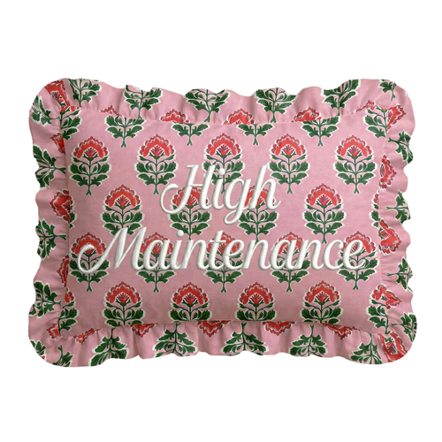 Floral-patterned pillow with 'High Maintenance' text on a pink background