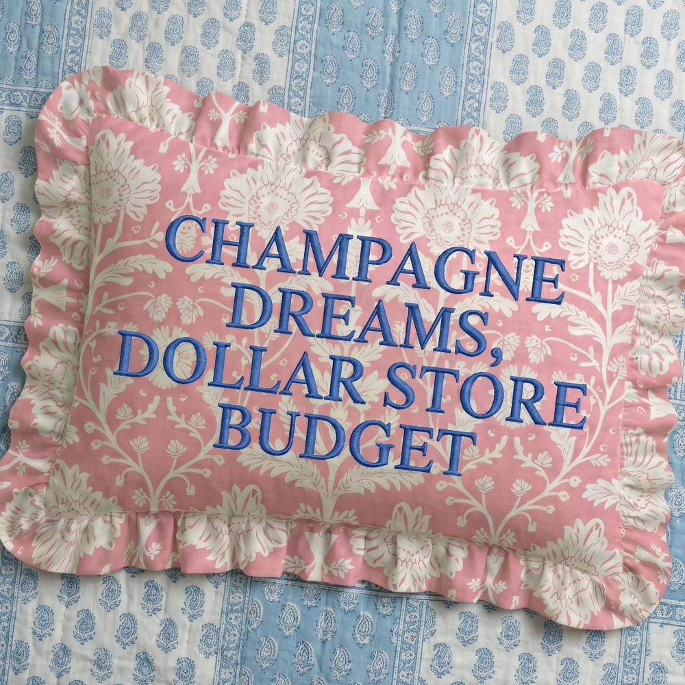 Decorative pillow with floral pattern and text on a blue and white patterned background